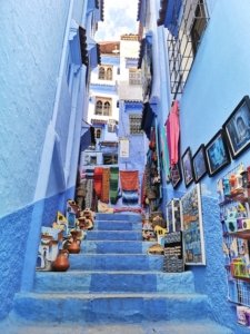 A stunning, narrow blue alleyway characteristic of Chefchaouen the blue city, inviting exploration by adventurous female travelers.