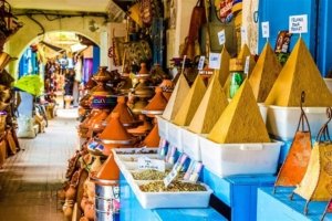 Marrakech vs Fes: A vibrant display of colorful spices in the bustling souks of Marrakech, reflecting the city's commercial energy.