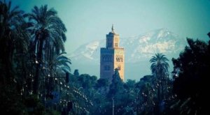 Marrakech vs Fes: The iconic Koutoubia Mosque in Marrakech standing tall against the backdrop of the majestic Atlas Mountains.